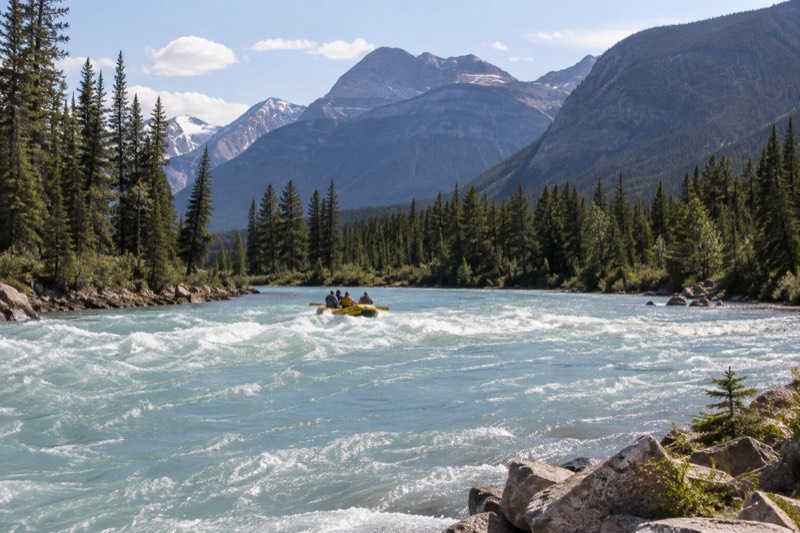 River category card, showing a raft carrying paddlers through a splashy stretch of the Athabasca River, one of six river-active tours compared here, from a calm two-hour float to Class III whitewater.