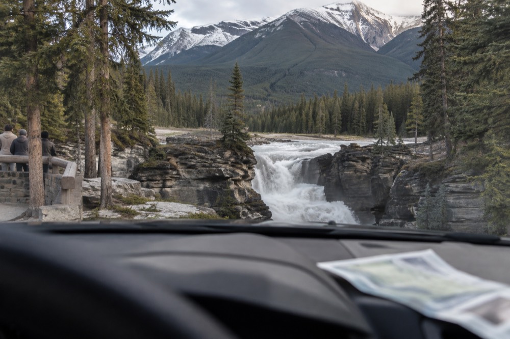 A park pass displayed on a vehicle dashboard at a Jasper trailhead