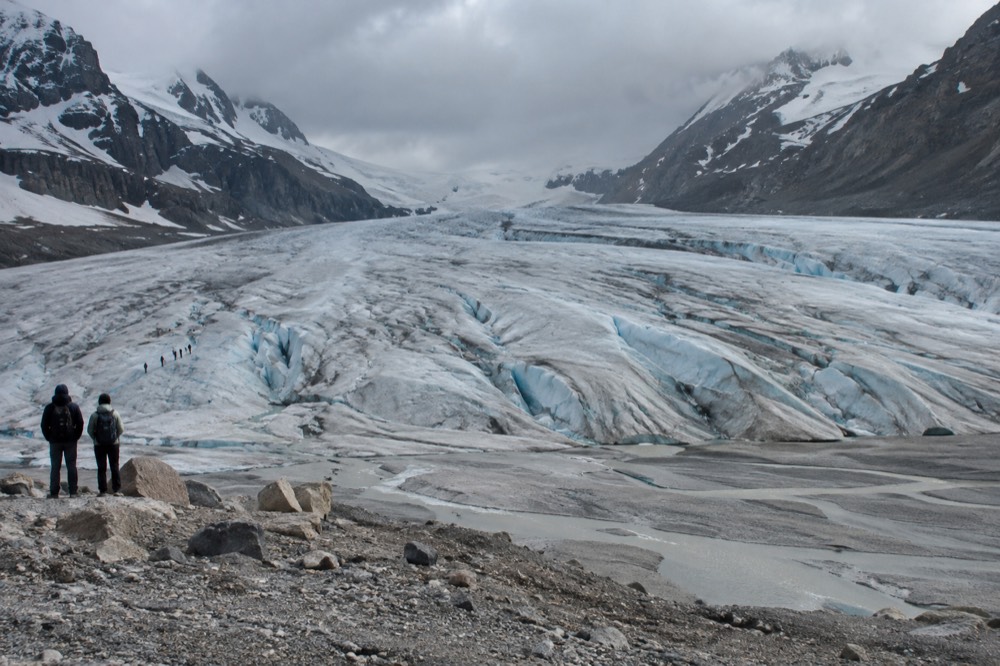 Crevasses and meltwater channels scoring the surface of a glacier under low clouds