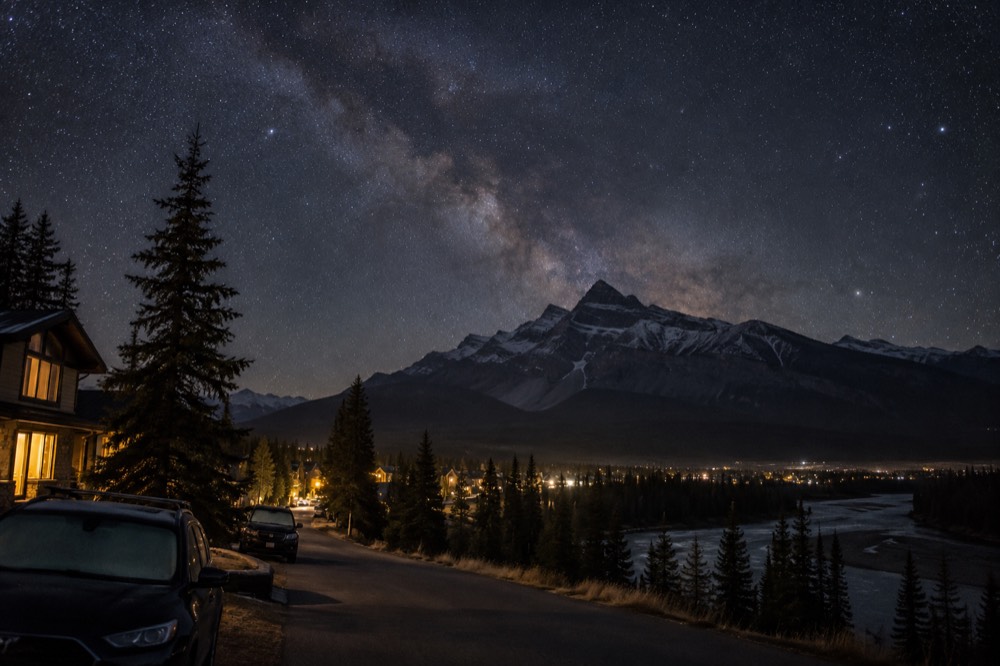 Milky Way arching over a dark mountain silhouette at night