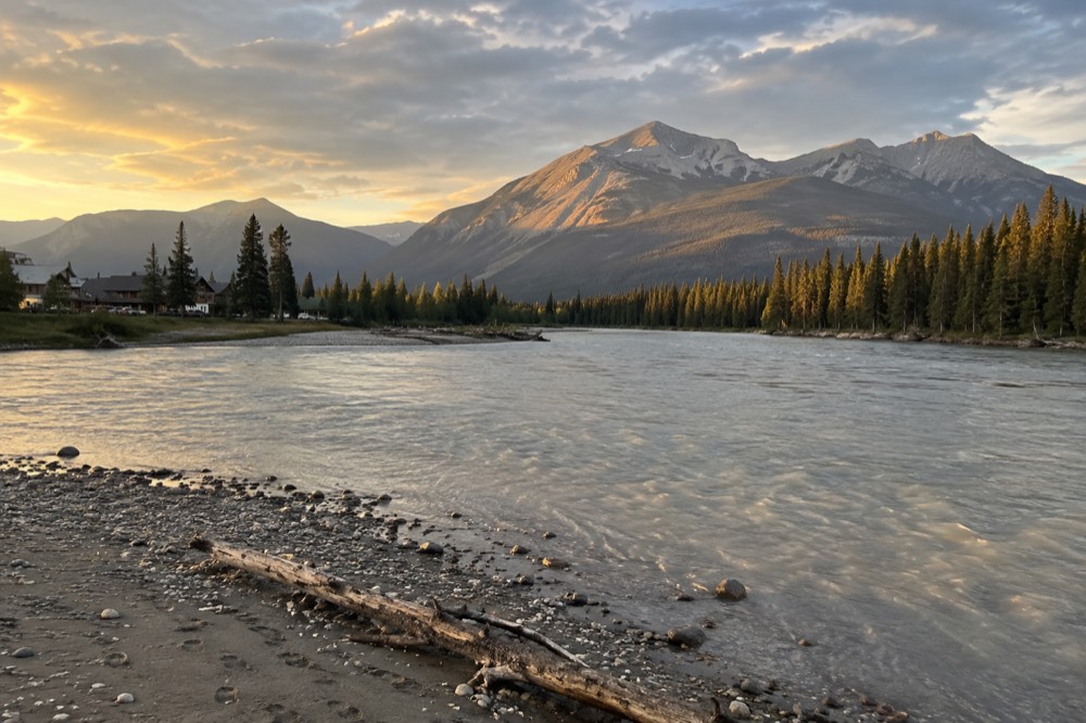 Calm river winding through a wide mountain valley in late afternoon light
